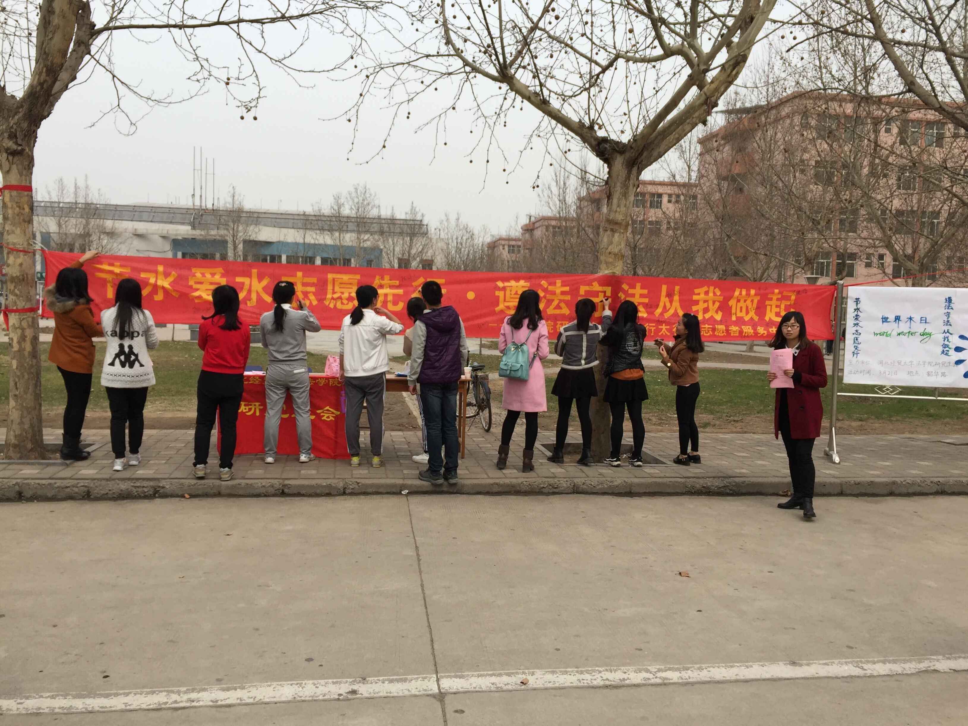 同学们在节水宣传条幅上签名.jpg 同学们在节水宣传条幅上签名.jpg
